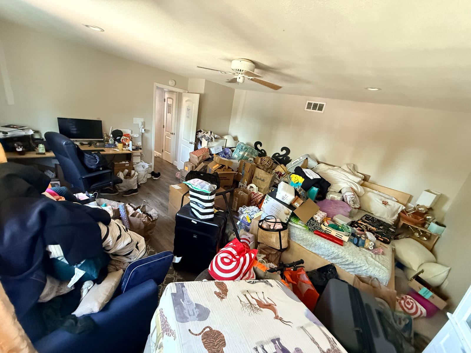 Living room before (alternate angle): piled high with items and no clear floor space