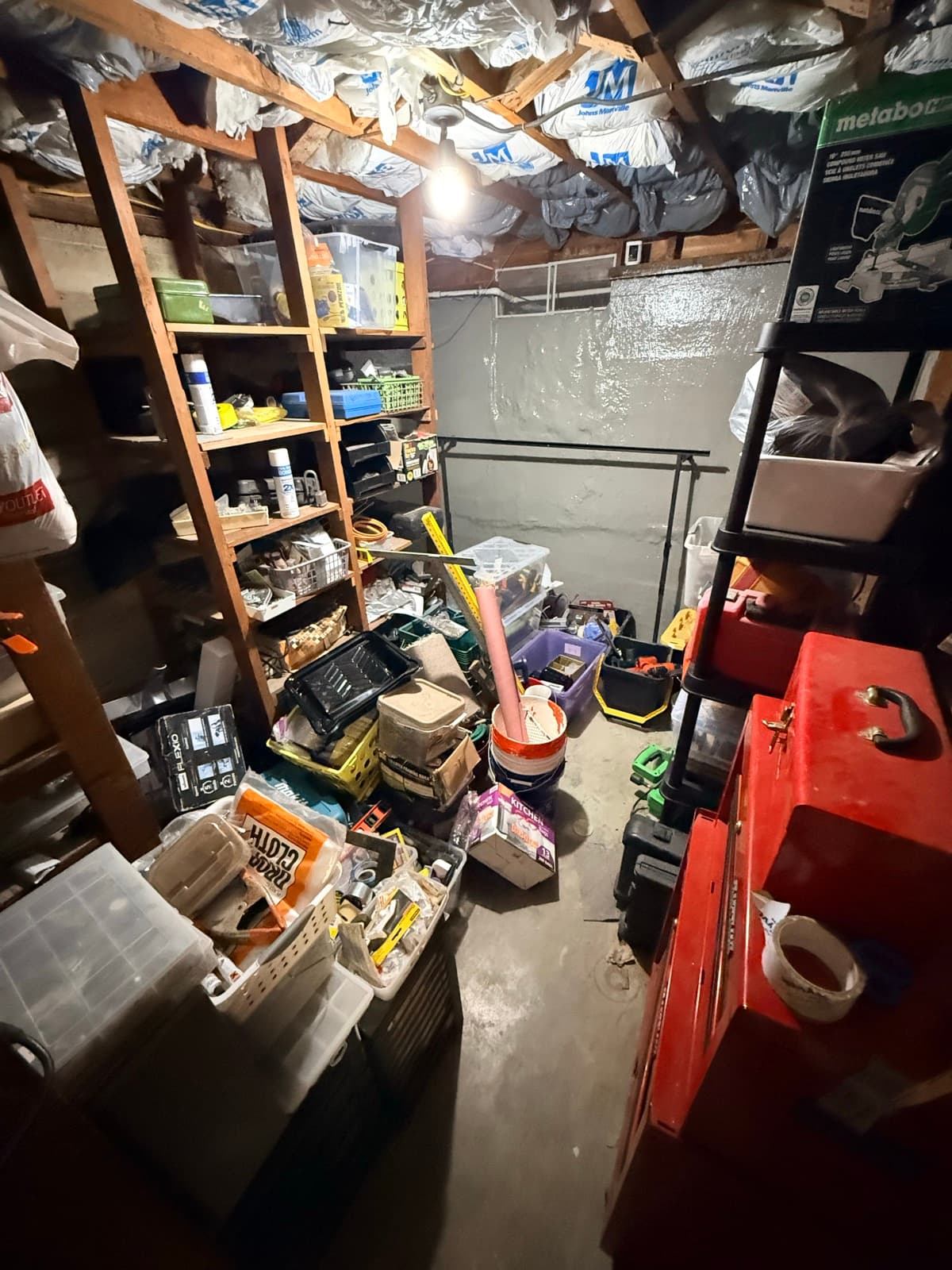 Small storage room before: dark and filled with tools and equipment