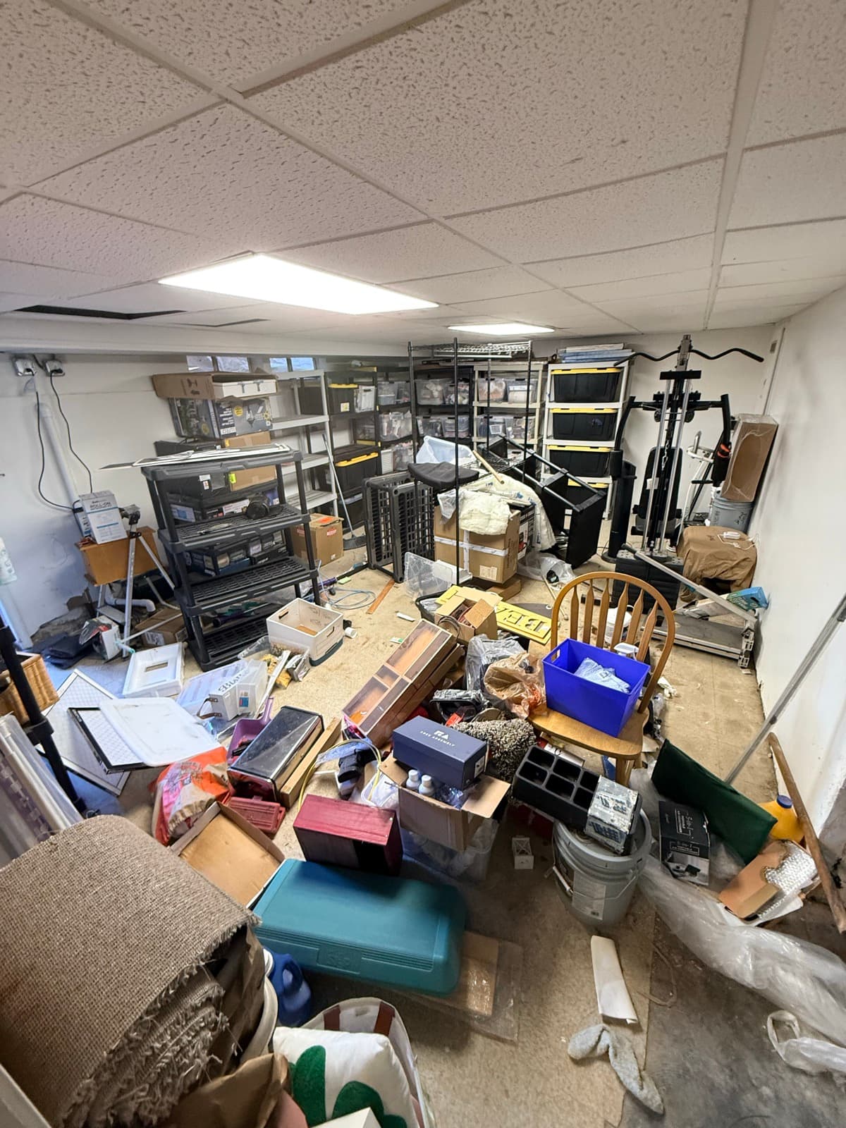 Storage unit before: crammed with furniture, electronics, and boxes