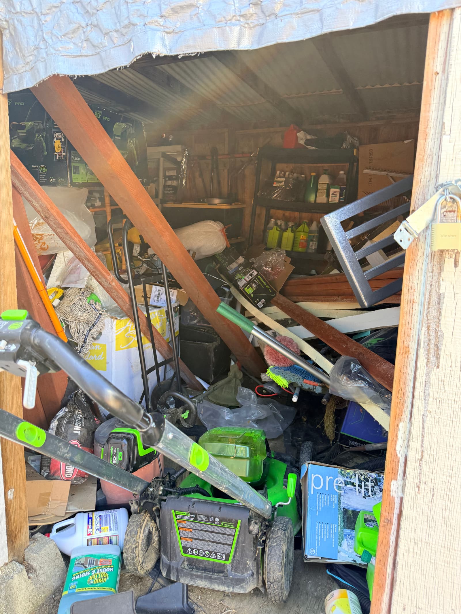 Shed before: completely chaotic, tools and boxes spilling out with no organization