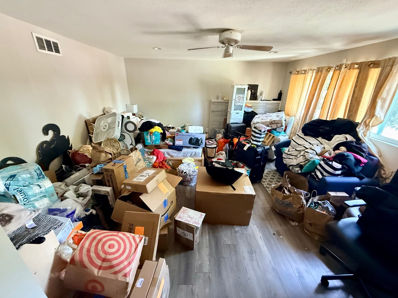 Living room before: heavily cluttered with boxes and items