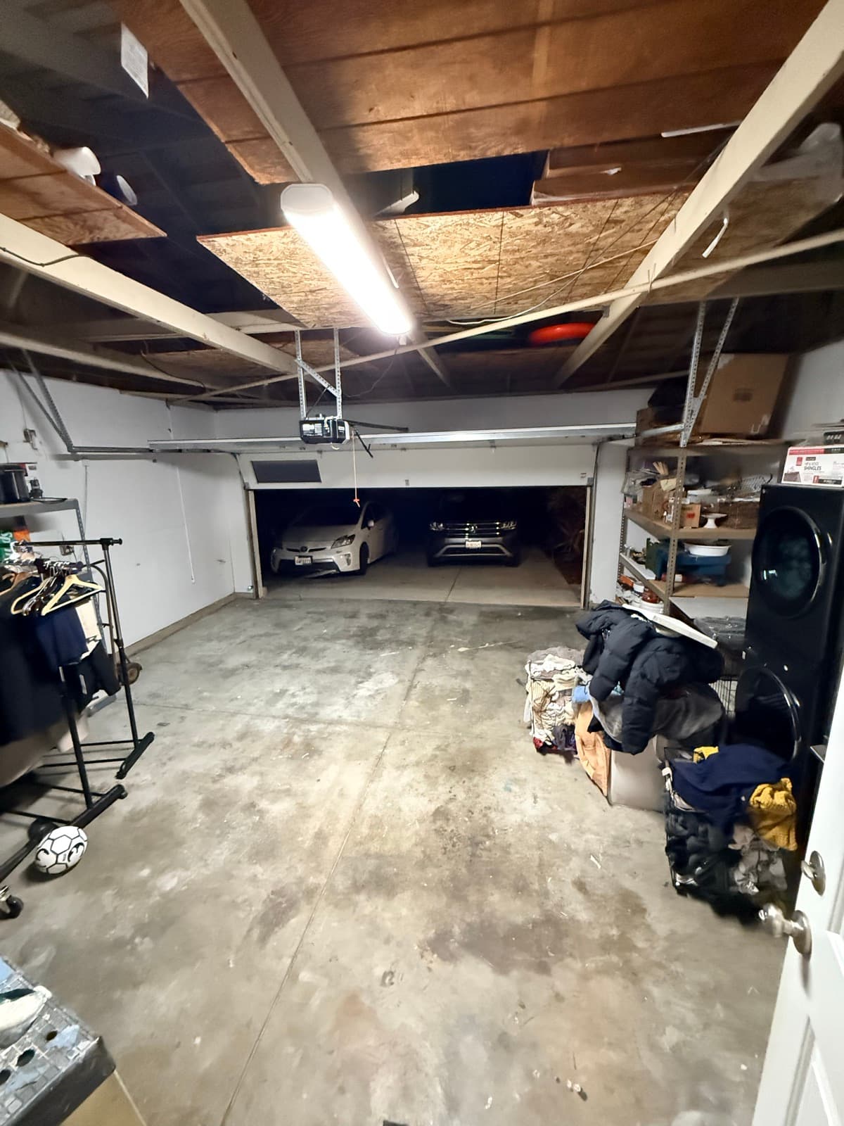 Garage after: clear floor, both cars fit, organized storage